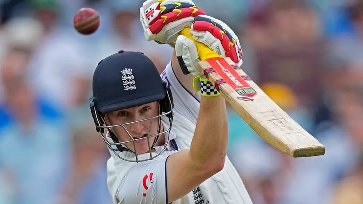 Harry Brook biography: Harry Brook playing a pull shot in England Test whites with the ball in the air, England crest on helmet