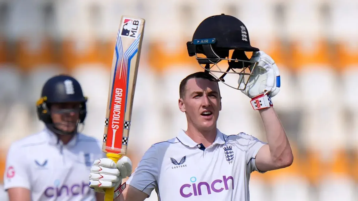 Harry Brook biography: Harry Brook raising helmet and bat in England Test whites, celebrating his triple century against Pakistan in Multan