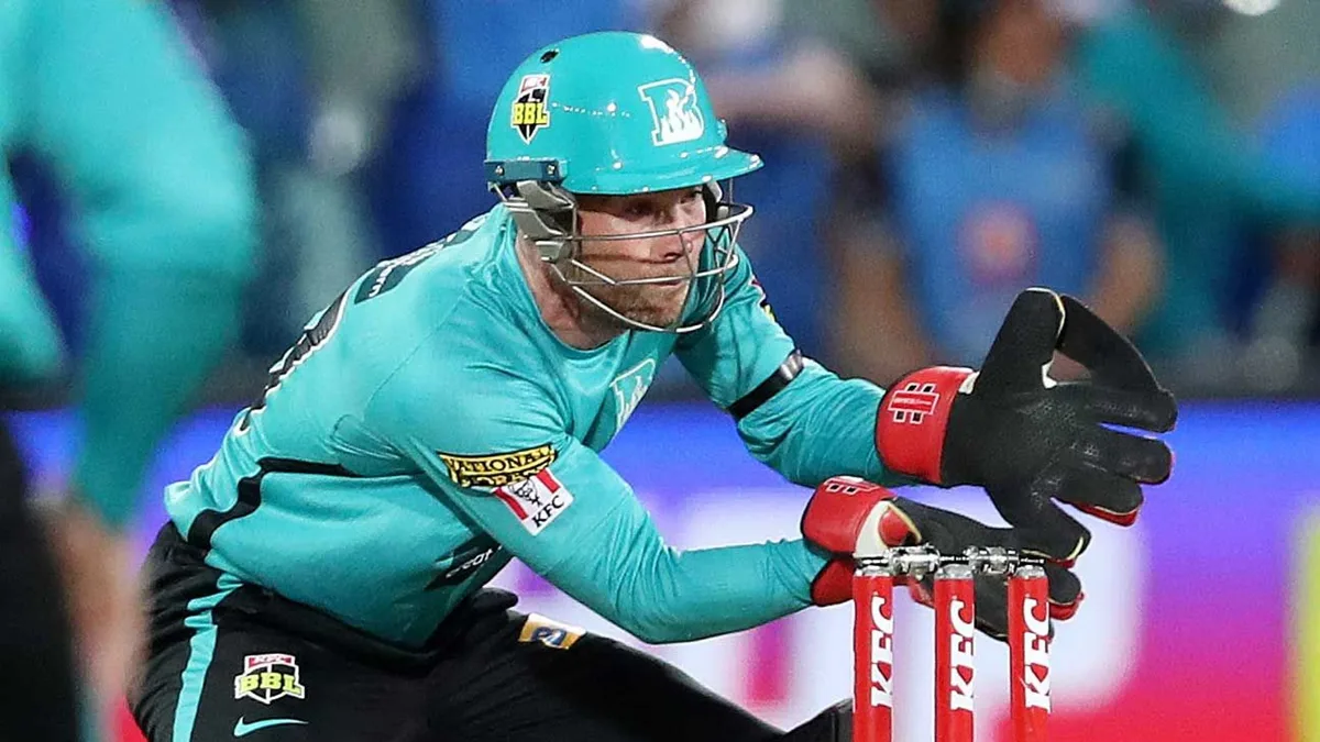 BBL signings: Sydney Thunder / Brisbane Heat: Jimmy Peirson keeps wicket for Brisbane Heat in teal helmet and red-black gloves behind the stumps