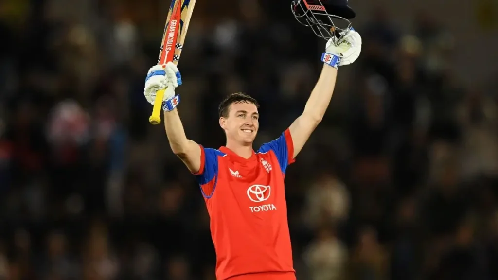 Harry Brook biography: Harry Brook raising his bat and helmet in the red England ODI kit while celebrating his century against Sri Lanka at Southampton